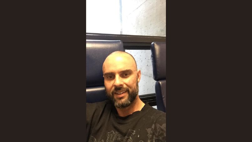 Un homme de 35 ans regarde la caméra.